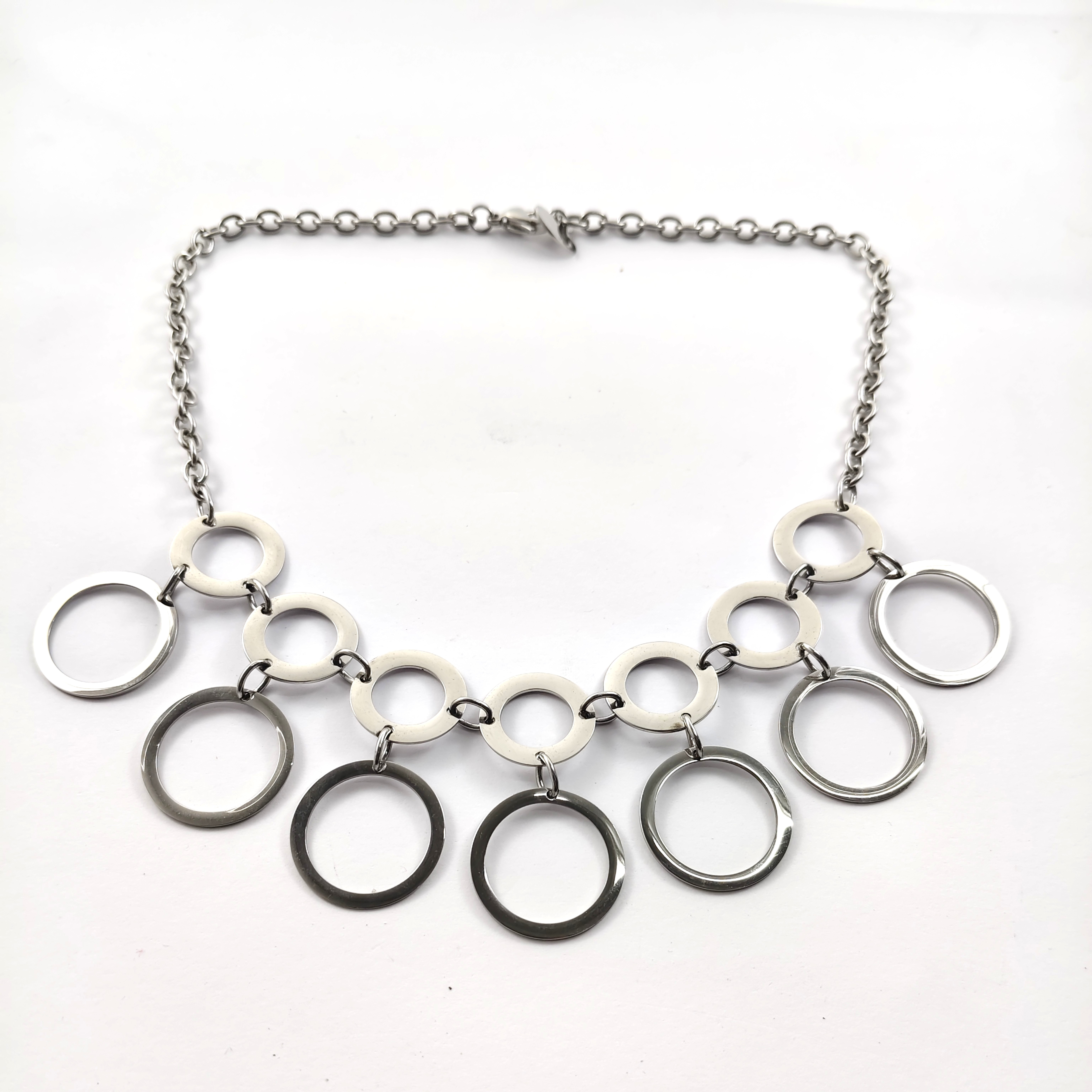 Collier en Acier Inoxydable – Cascade d’Anneaux Géométriques Collier en Acier Inoxydable – Cascade d’Anneaux Géométriques