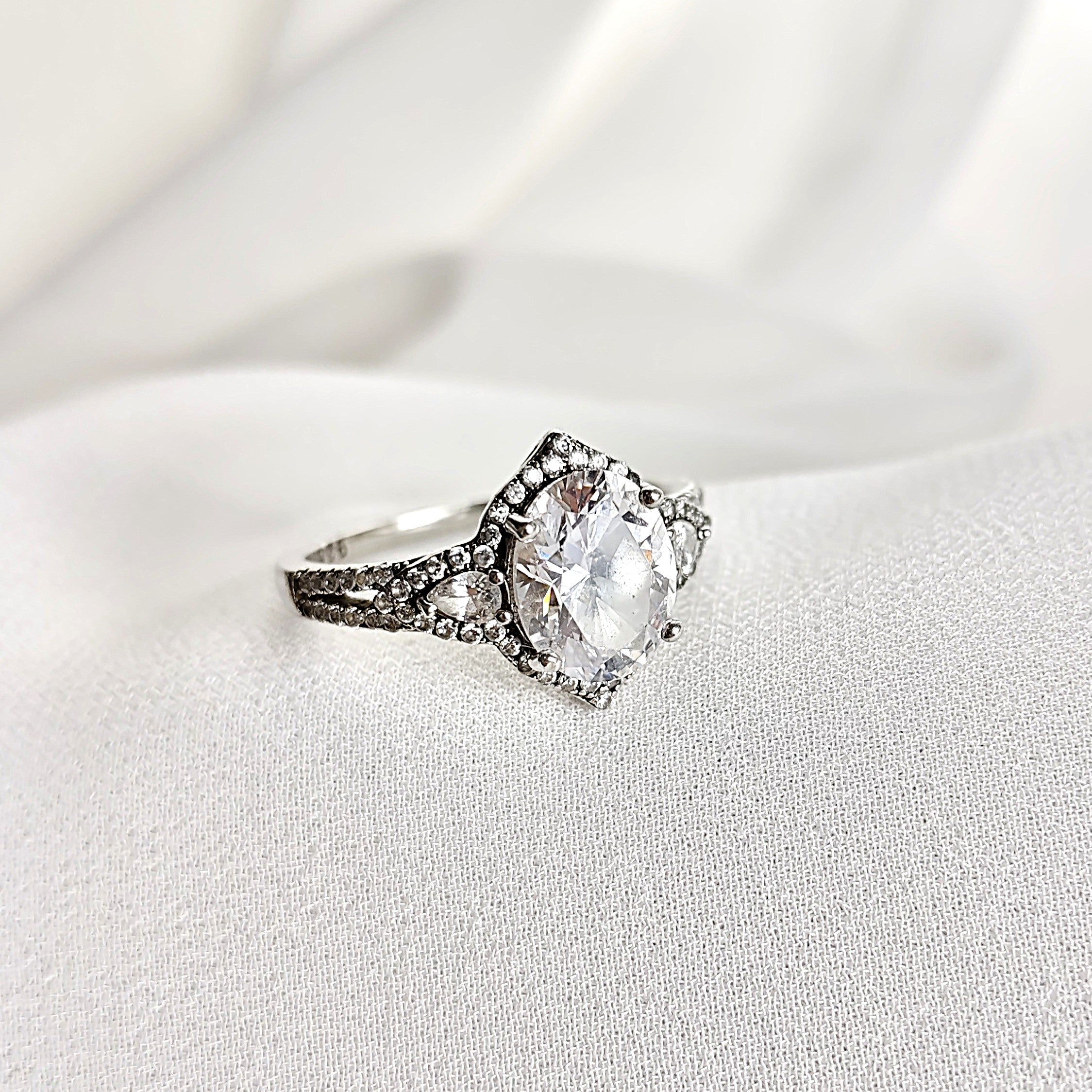 Bague Solitaire en Argent Rhodié avec Zirconium Oval et Pavé Étincelant Bague Solitaire en Argent Rhodié avec Zirconium Oval et Pavé Étincelant