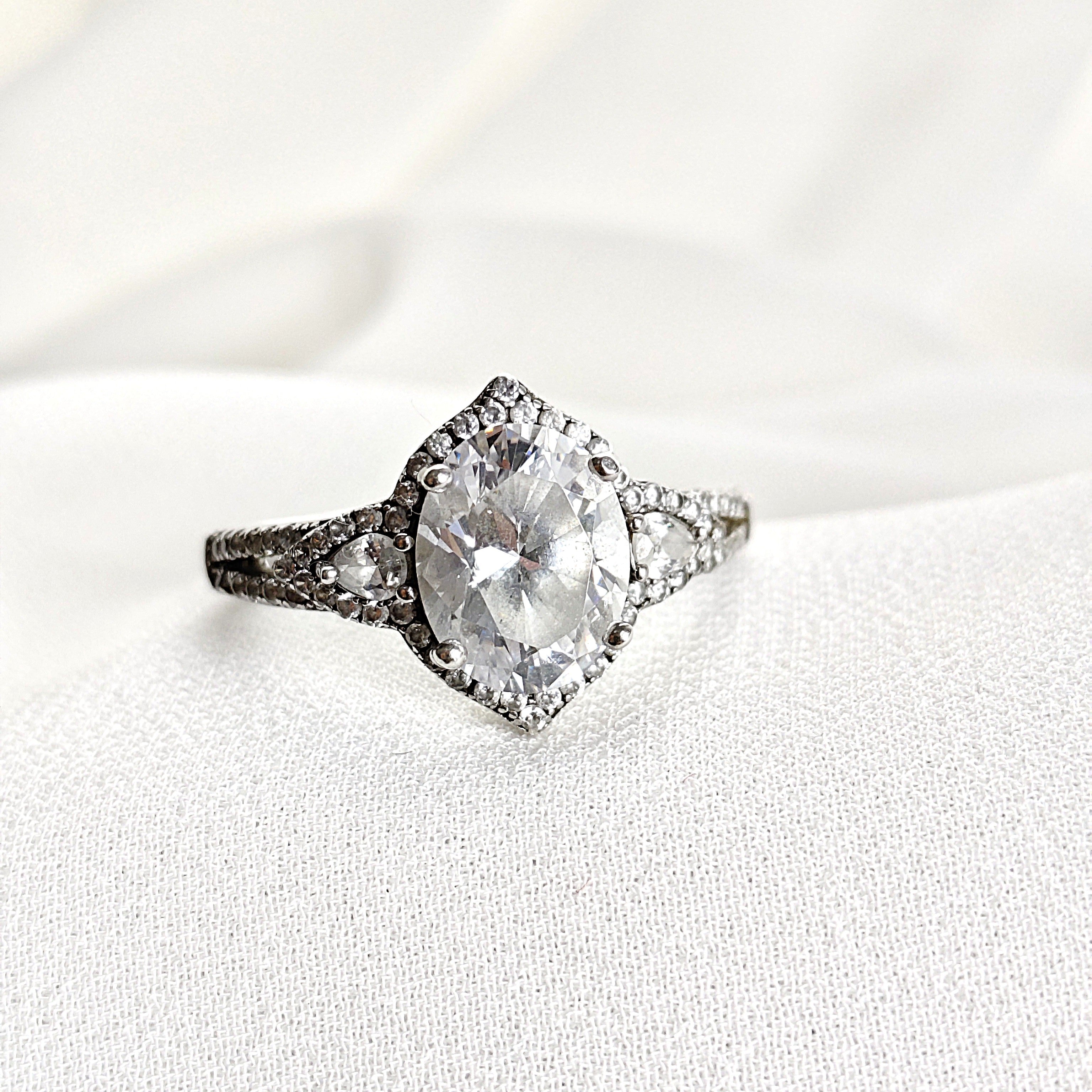 Bague Solitaire en Argent Rhodié avec Zirconium Oval et Pavé Étincelant Bague Solitaire en Argent Rhodié avec Zirconium Oval et Pavé Étincelant