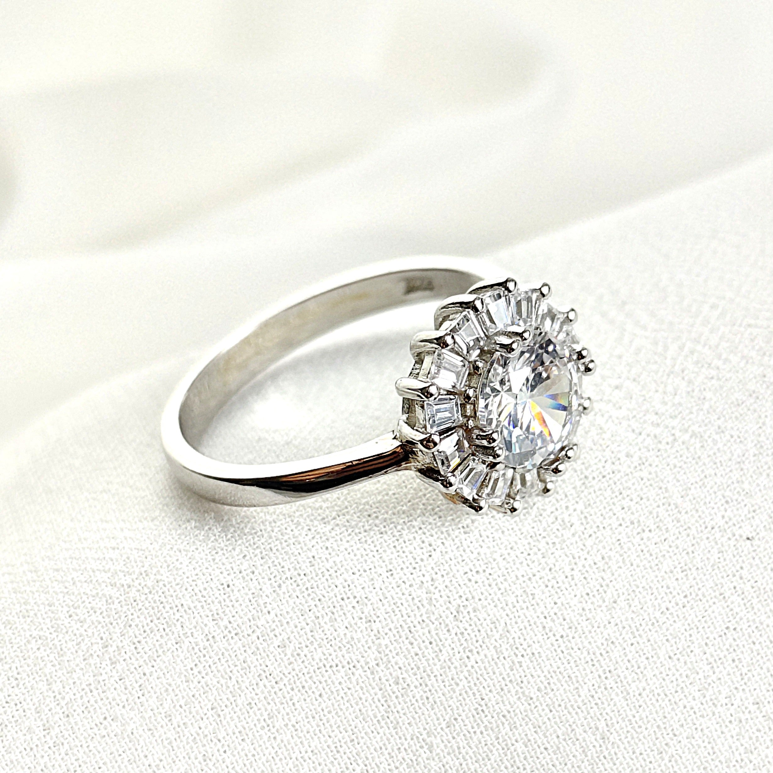 Bague en argent rhodié avec pierre centrale et halo de zircons Bague en argent rhodié avec pierre centrale et halo de zircons