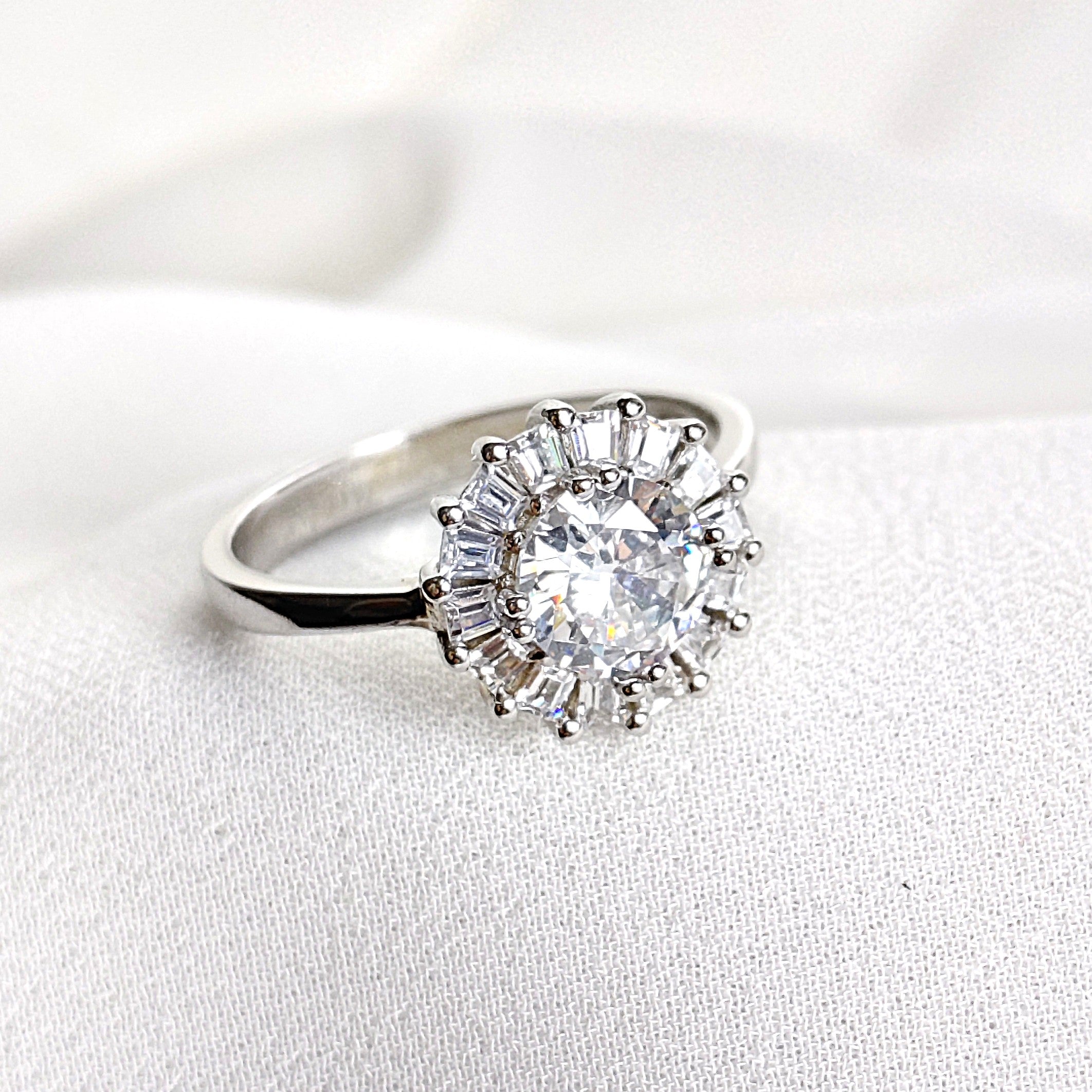 Bague en argent rhodié avec pierre centrale et halo de zircons Bague en argent rhodié avec pierre centrale et halo de zircons
