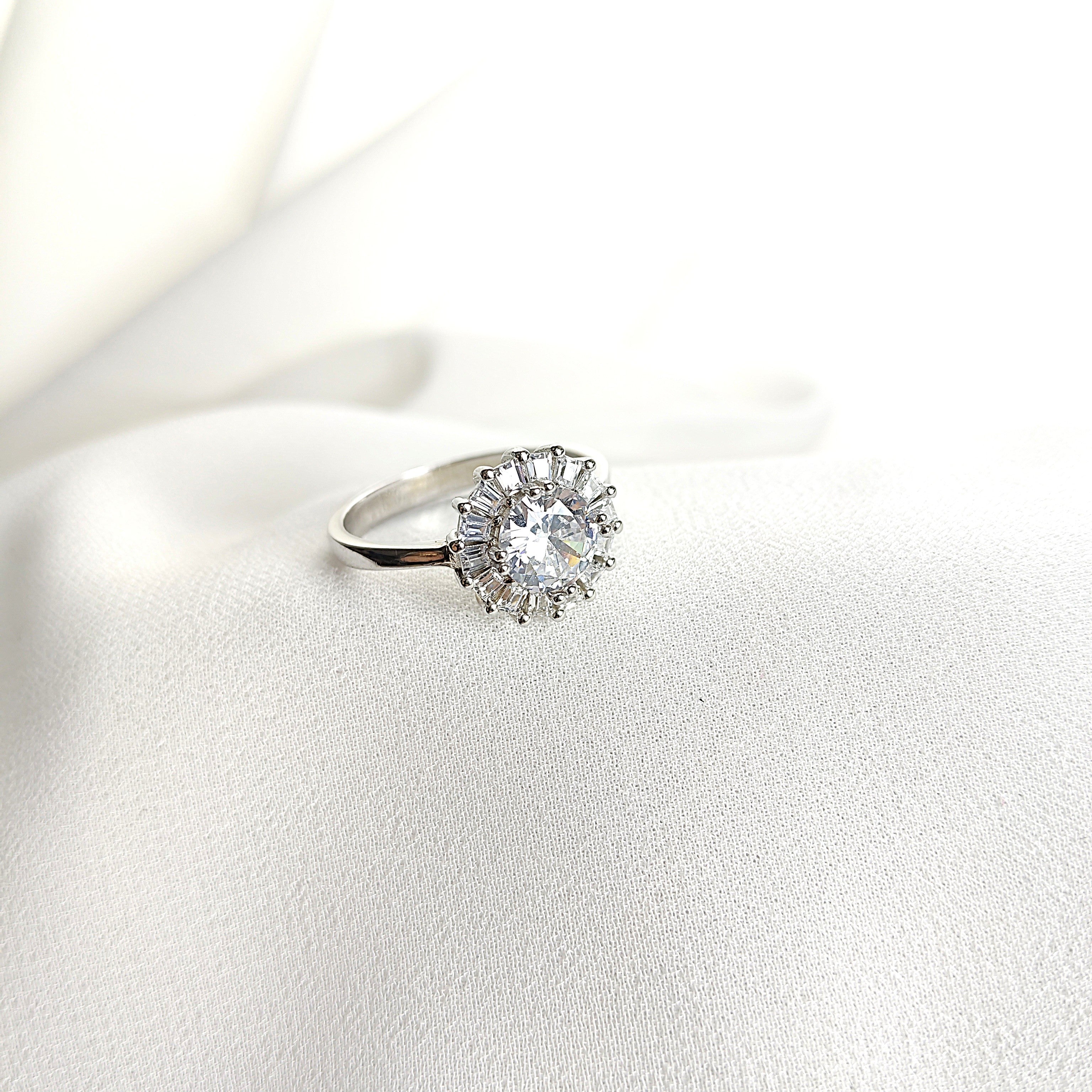 Bague en argent rhodié avec pierre centrale et halo de zircons Bague en argent rhodié avec pierre centrale et halo de zircons