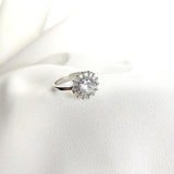 Bague en argent rhodié avec pierre centrale et halo de zircons Bague en argent rhodié avec pierre centrale et halo de zircons