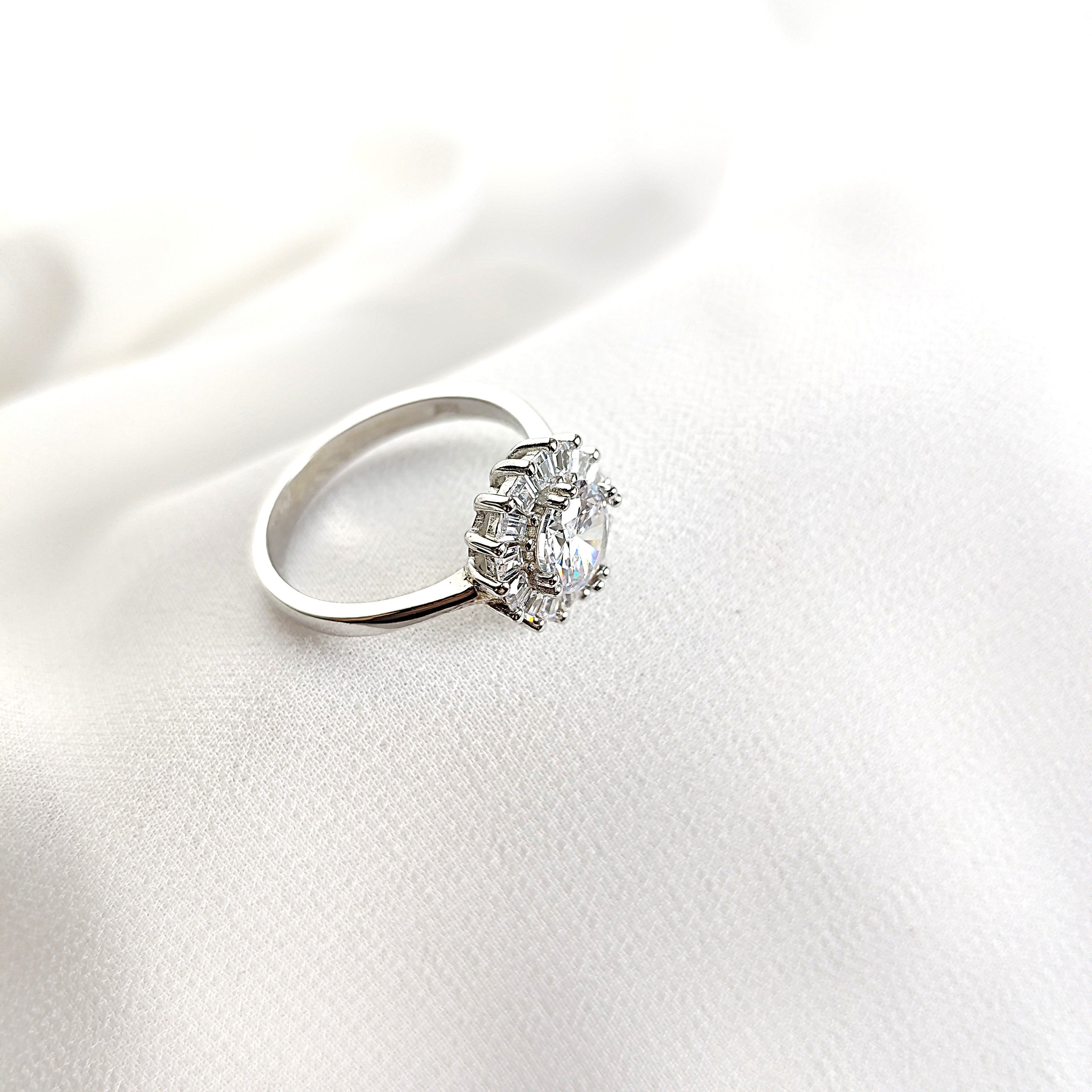 Bague en argent rhodié avec pierre centrale et halo de zircons Bague en argent rhodié avec pierre centrale et halo de zircons