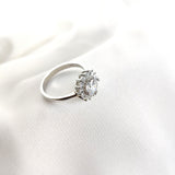 Bague en argent rhodié avec pierre centrale et halo de zircons Bague en argent rhodié avec pierre centrale et halo de zircons