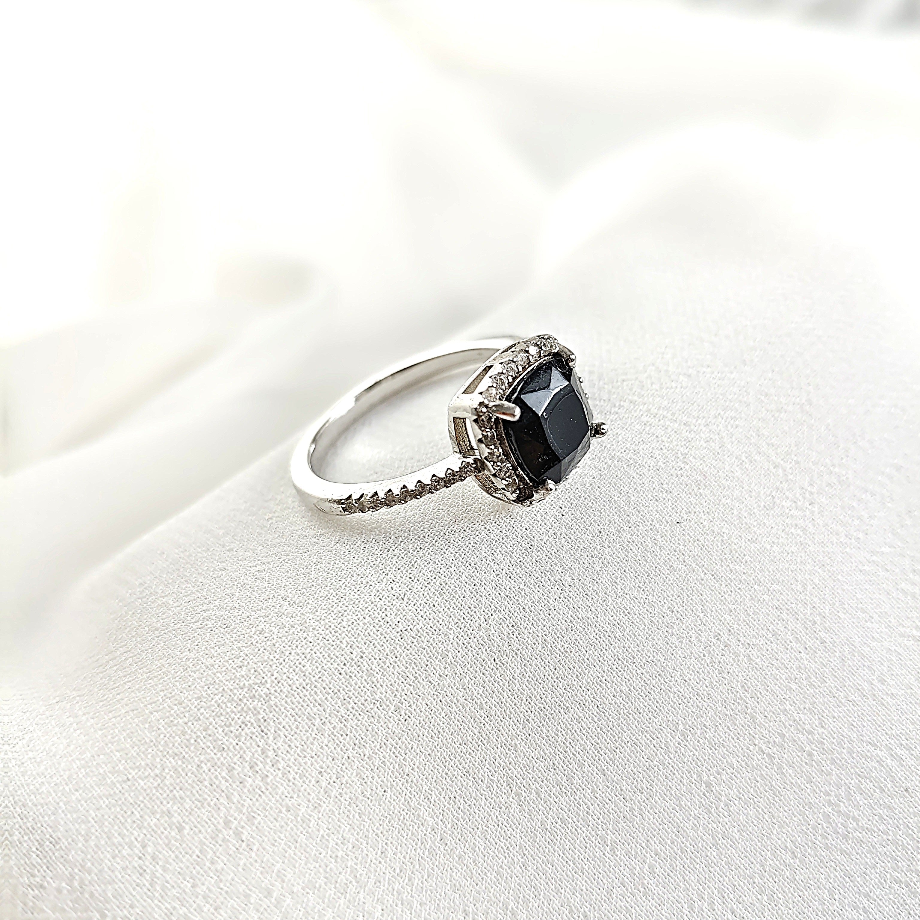 Bague en argent rhodié avec pierre noire et halo de zircons Bague en argent rhodié avec pierre noire et halo de zircons