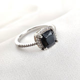 Bague en argent rhodié avec pierre noire et halo de zircons Bague en argent rhodié avec pierre noire et halo de zircons