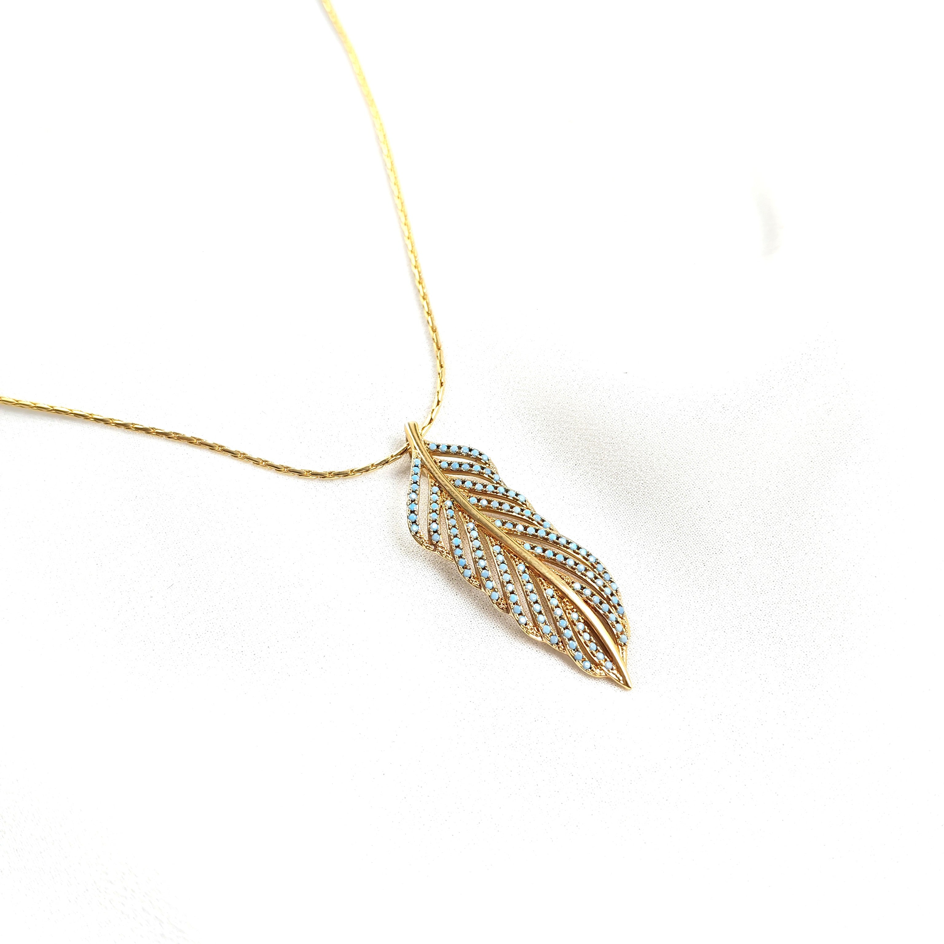Collier en plaqué or avec pendentif plume et pierres turquoise Collier en plaqué or avec pendentif plume et pierres turquoise