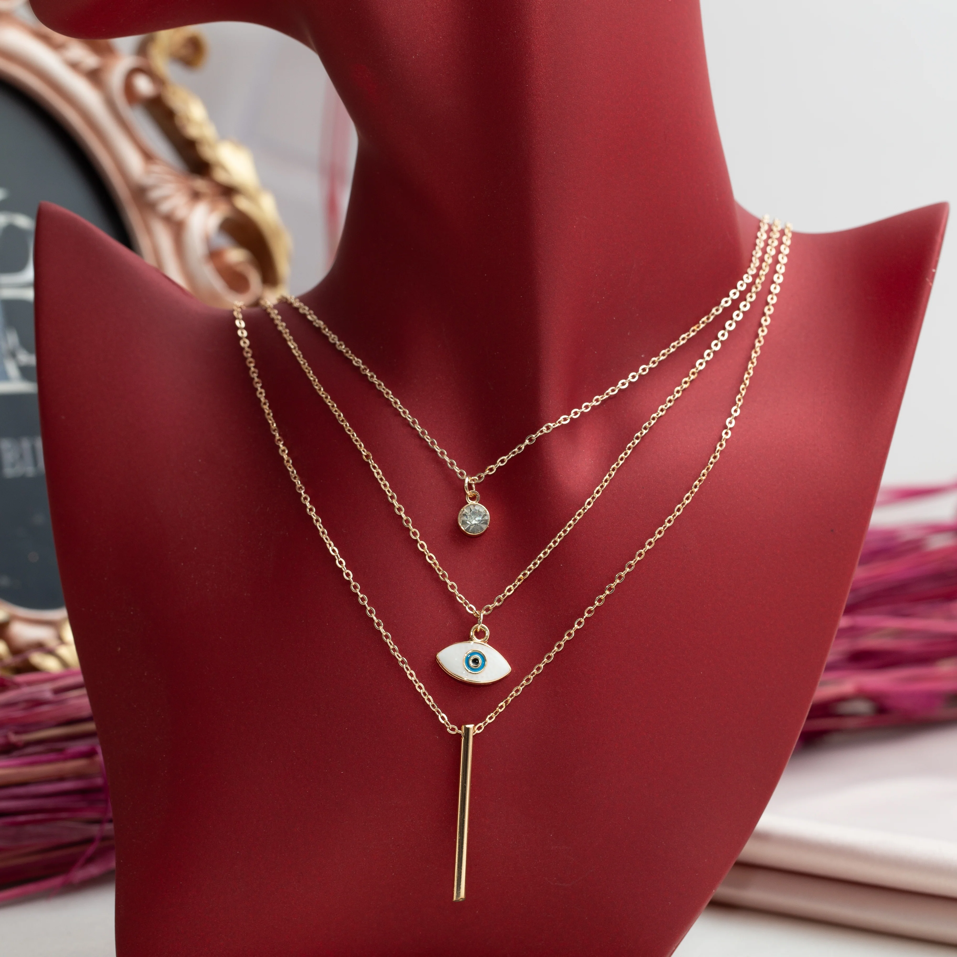 Collier Fantaisie Doré Multi-Rangs – Œil Protecteur, Barre Minimaliste et Strass Collier Fantaisie Doré Multi-Rangs – Œil Protecteur, Barre Minimaliste et Strass