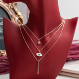 Collier Fantaisie Doré Multi-Rangs – Œil Protecteur, Barre Minimaliste et Strass Collier Fantaisie Doré Multi-Rangs – Œil Protecteur, Barre Minimaliste et Strass
