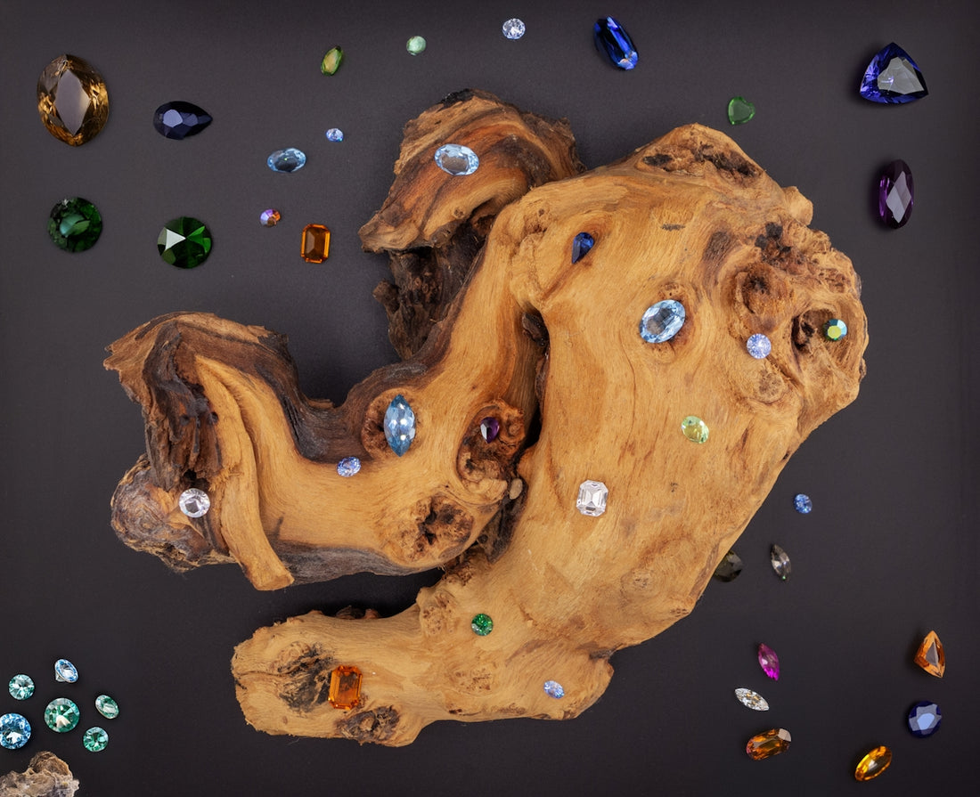 A piece of wood with many different colored stones on it