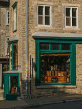 Stone building with a green-trimmed shop window.
