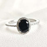 Bague en argent rhodié avec pierre noire et halo de zircons