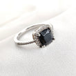 Bague en argent rhodié avec pierre noire et halo de zircons