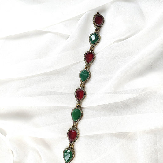 Gourmette antique en bronze avec pierres vertes et rouges