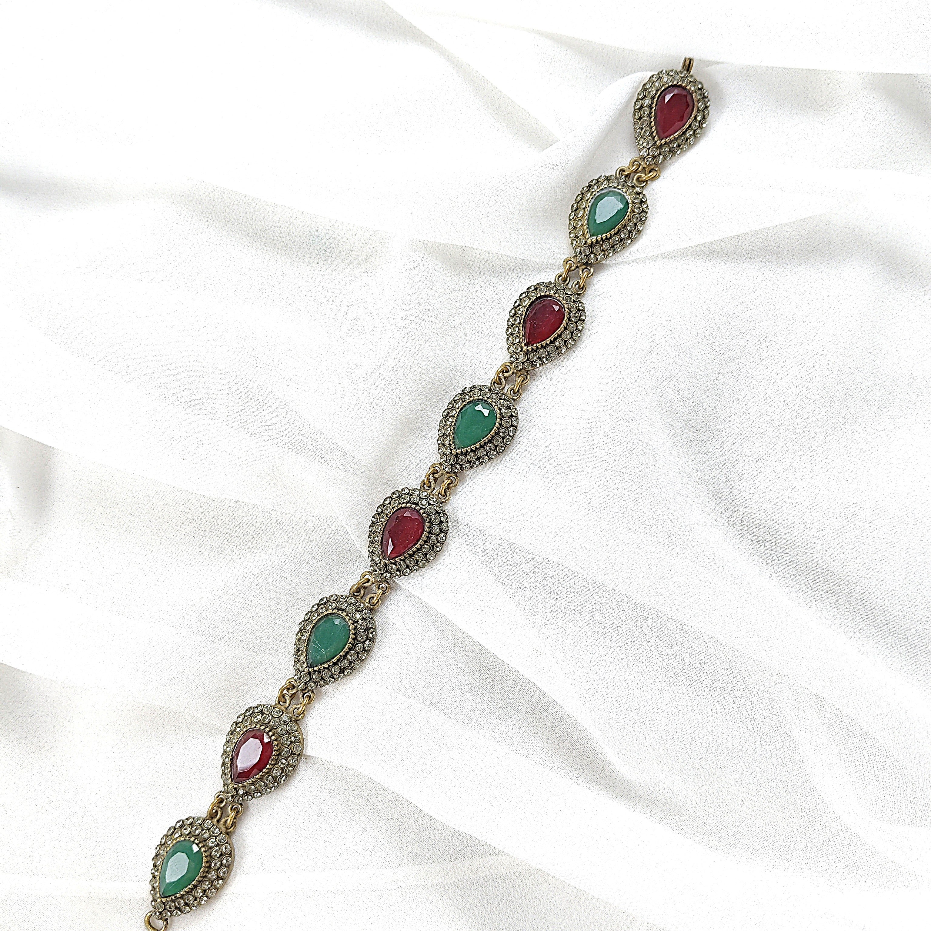 Gourmette antique en bronze avec pierres vertes et rouges