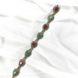 Gourmette antique en bronze avec pierres vertes et rouges