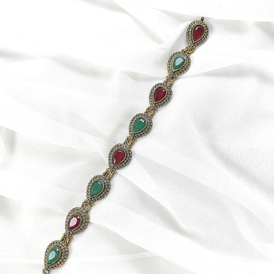 Gourmette antique en bronze avec pierres vertes et rouges